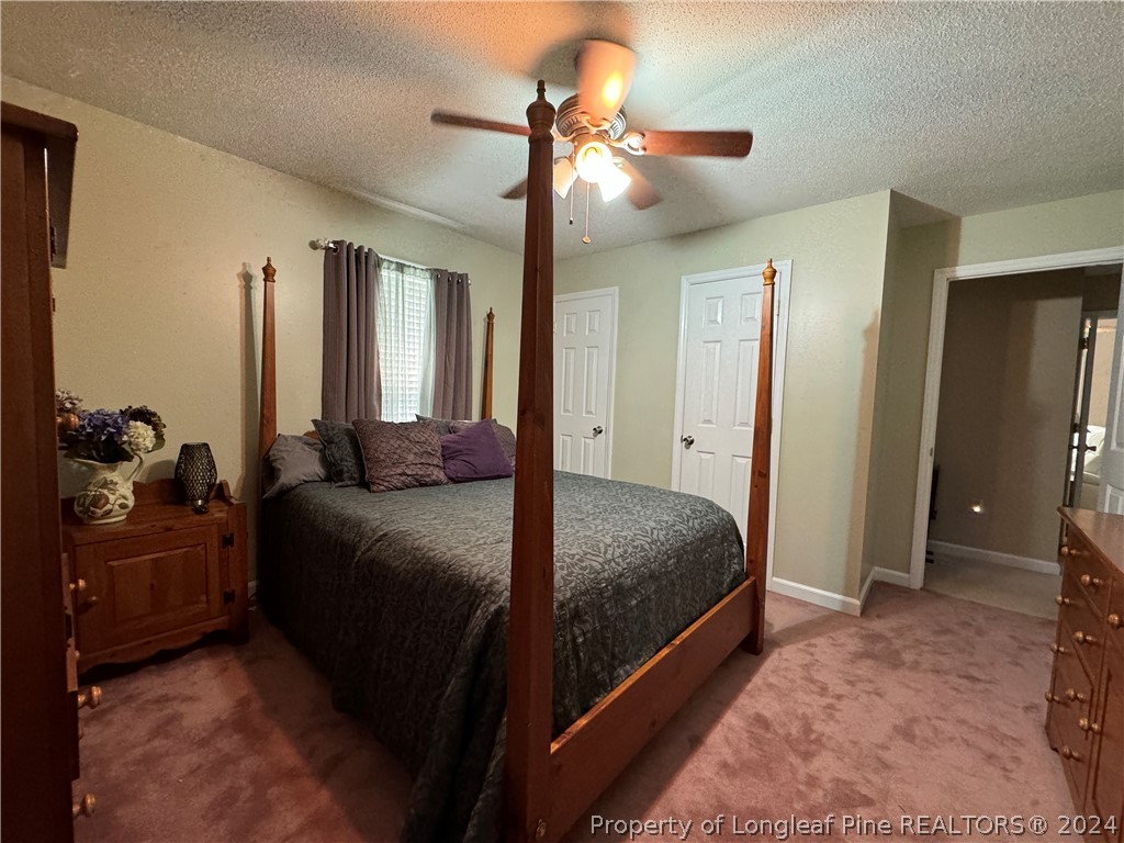 209 Old Farm Road Raeford, NC 28376 - Photo 29 of 45 a bedroom with a bed and a chandelier