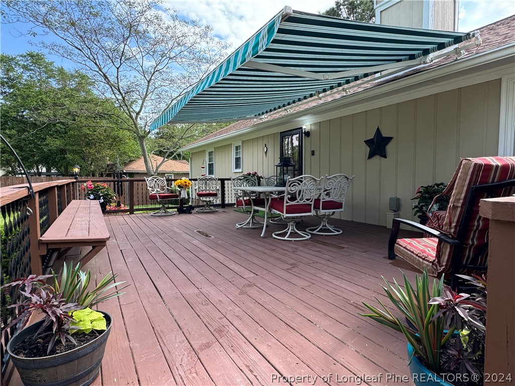 209 Old Farm Road Raeford, NC 28376 - Photo 41 of 45 a view of a patio with table and chairs potted plants and a barbeque