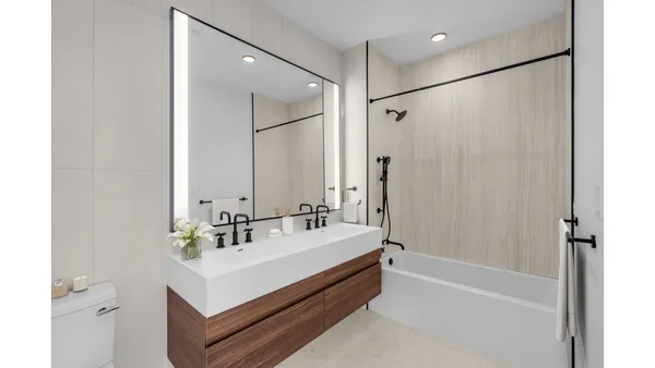 a bedroom with a bed and a flat tv screen next to a large window