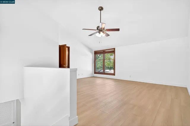 a view of a room with a ceiling fan and a window