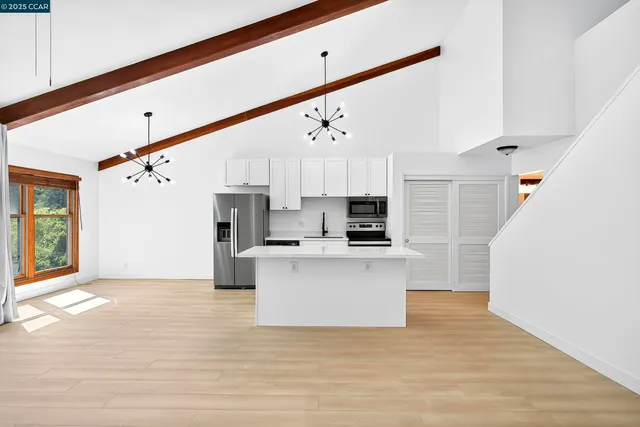 a view of kitchen with stainless steel appliances refrigerator stove microwave and cabinets