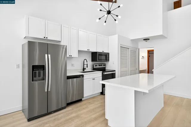 a kitchen with stainless steel appliances a refrigerator sink and microwave