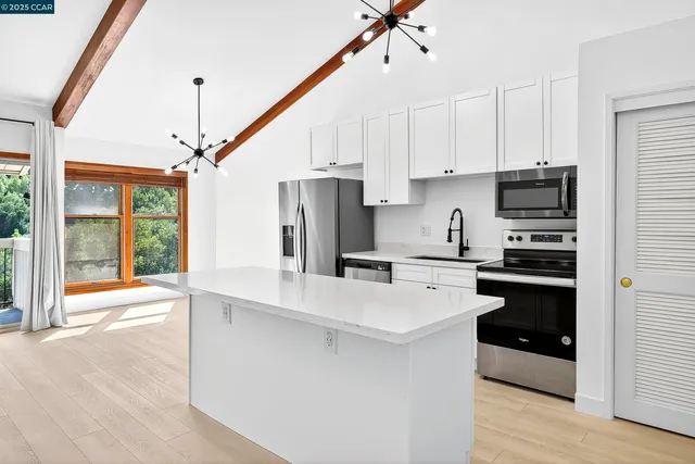 a kitchen with stainless steel appliances a refrigerator sink and cabinets