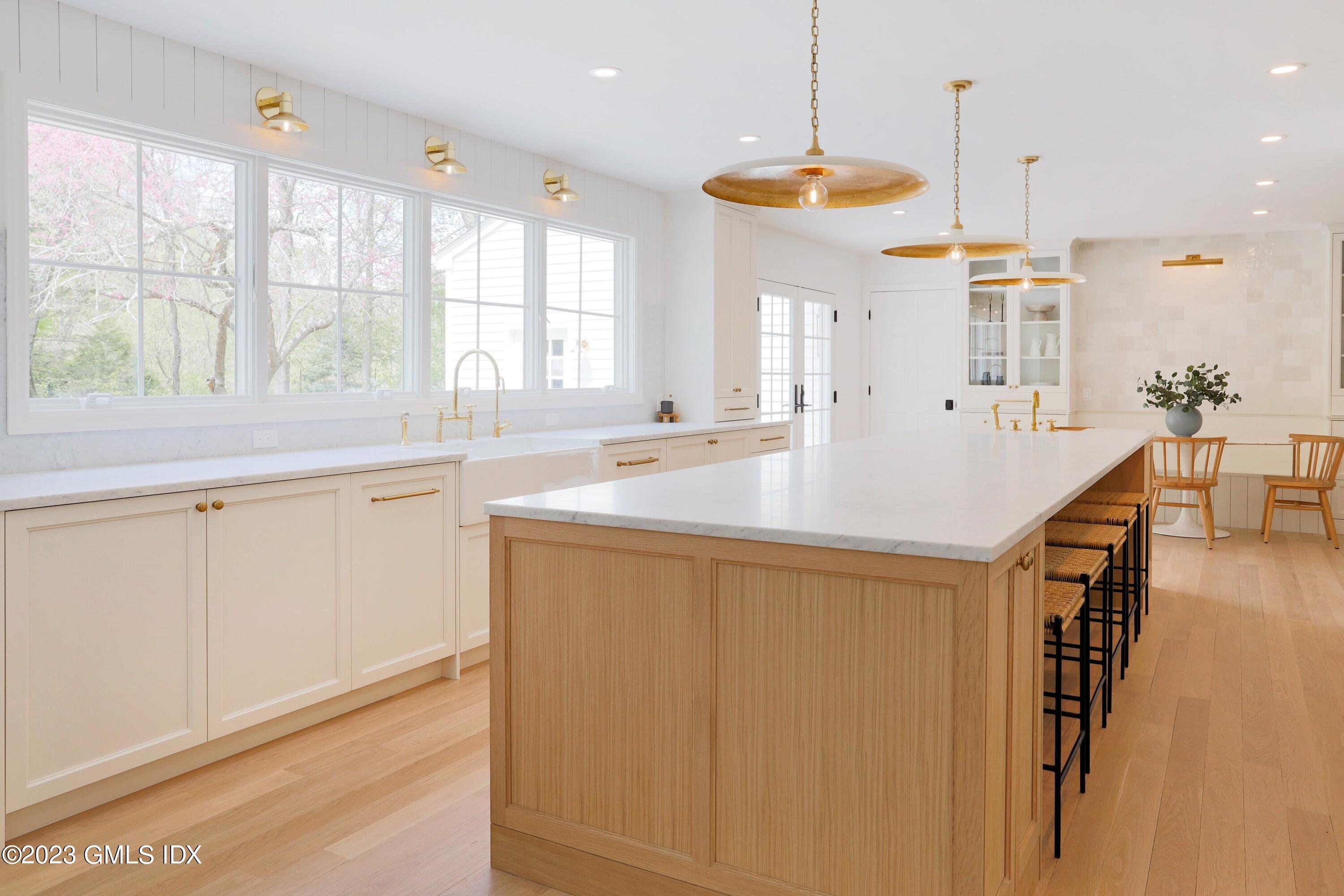 48 Old Mill Road Greenwich, CT 06831 - Photo 12 of 47 a large kitchen with kitchen island a large window a sink and stainless steel appliances