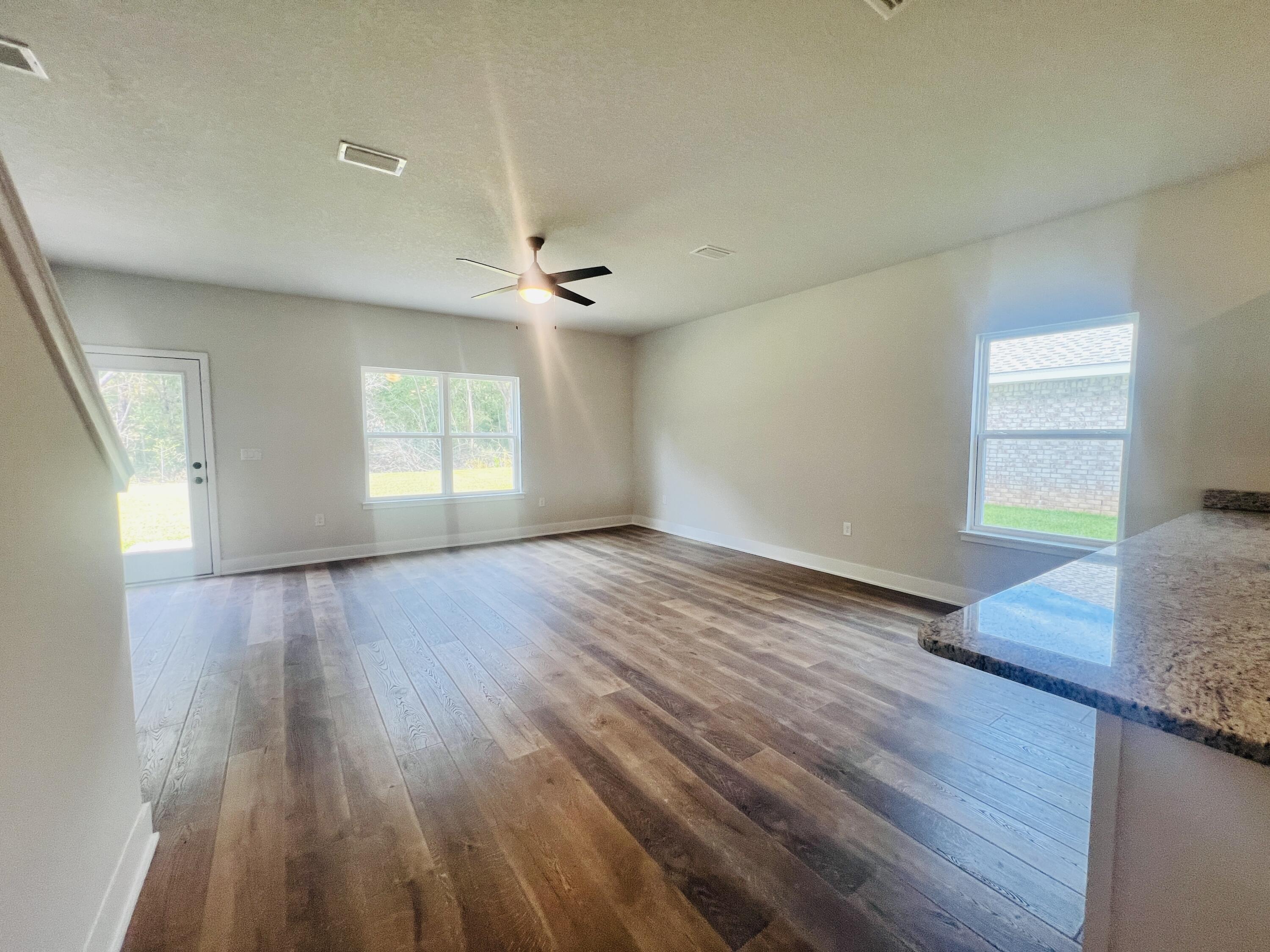 5299 Hidden Pines Circle Milton, FL 32583 - Photo 11 of 33 an empty room with wooden floor and windows
