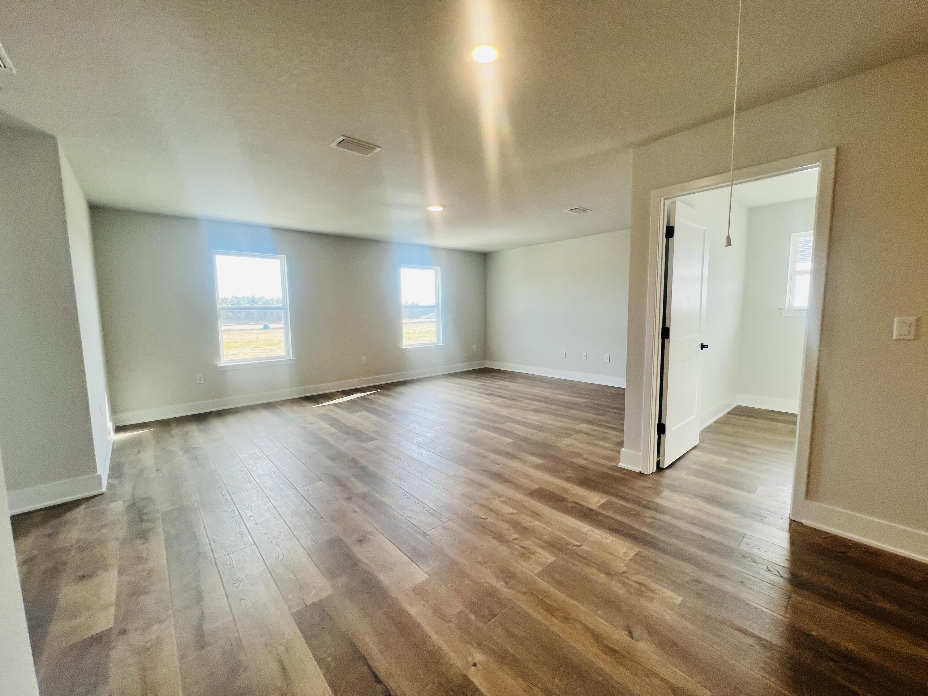 5299 Hidden Pines Circle Milton, FL 32583 - Photo 22 of 33 an empty room with wooden floor and windows