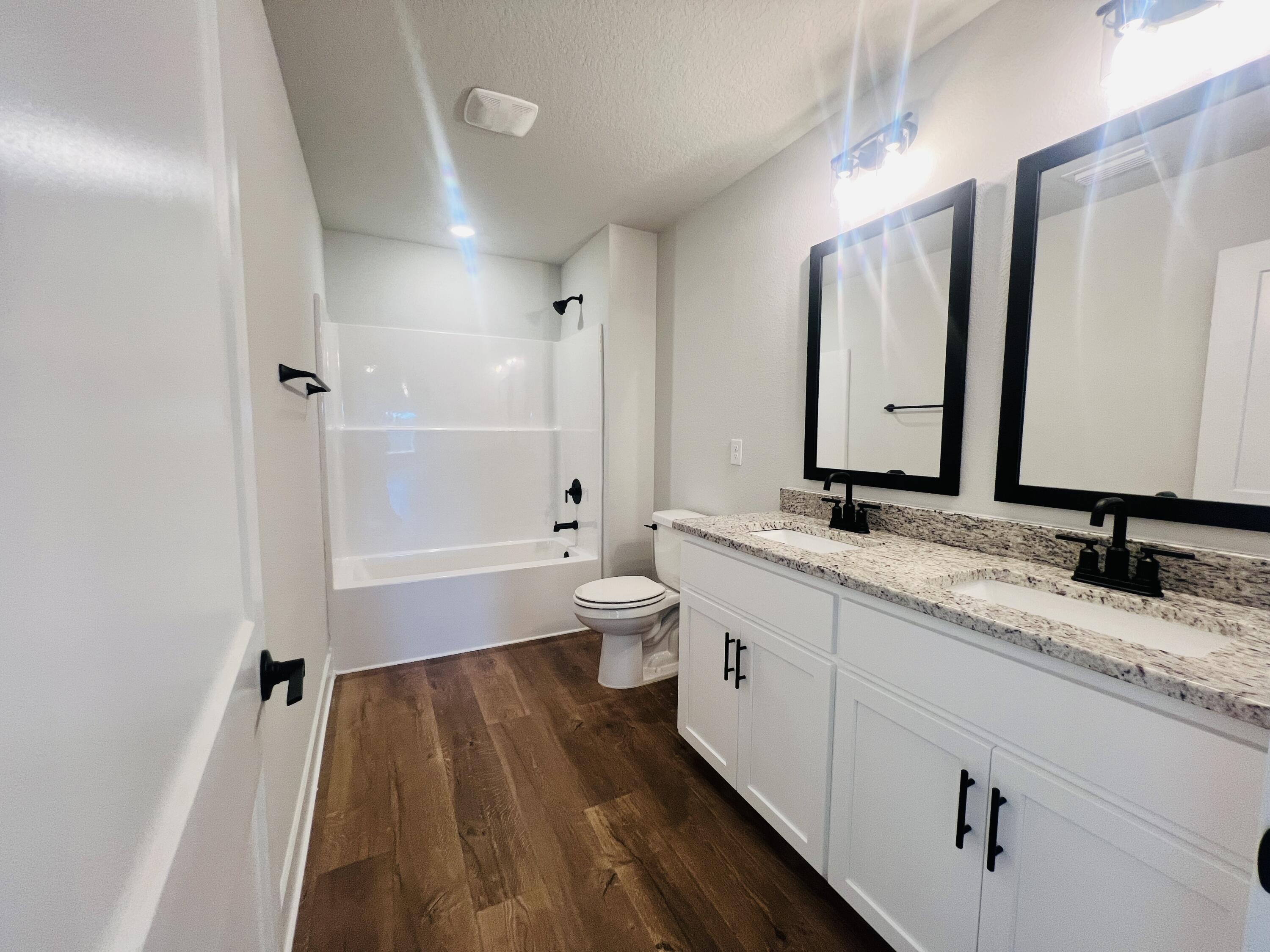 5299 Hidden Pines Circle Milton, FL 32583 - Photo 29 of 33 a bathroom with a sink a toilet and a large mirror