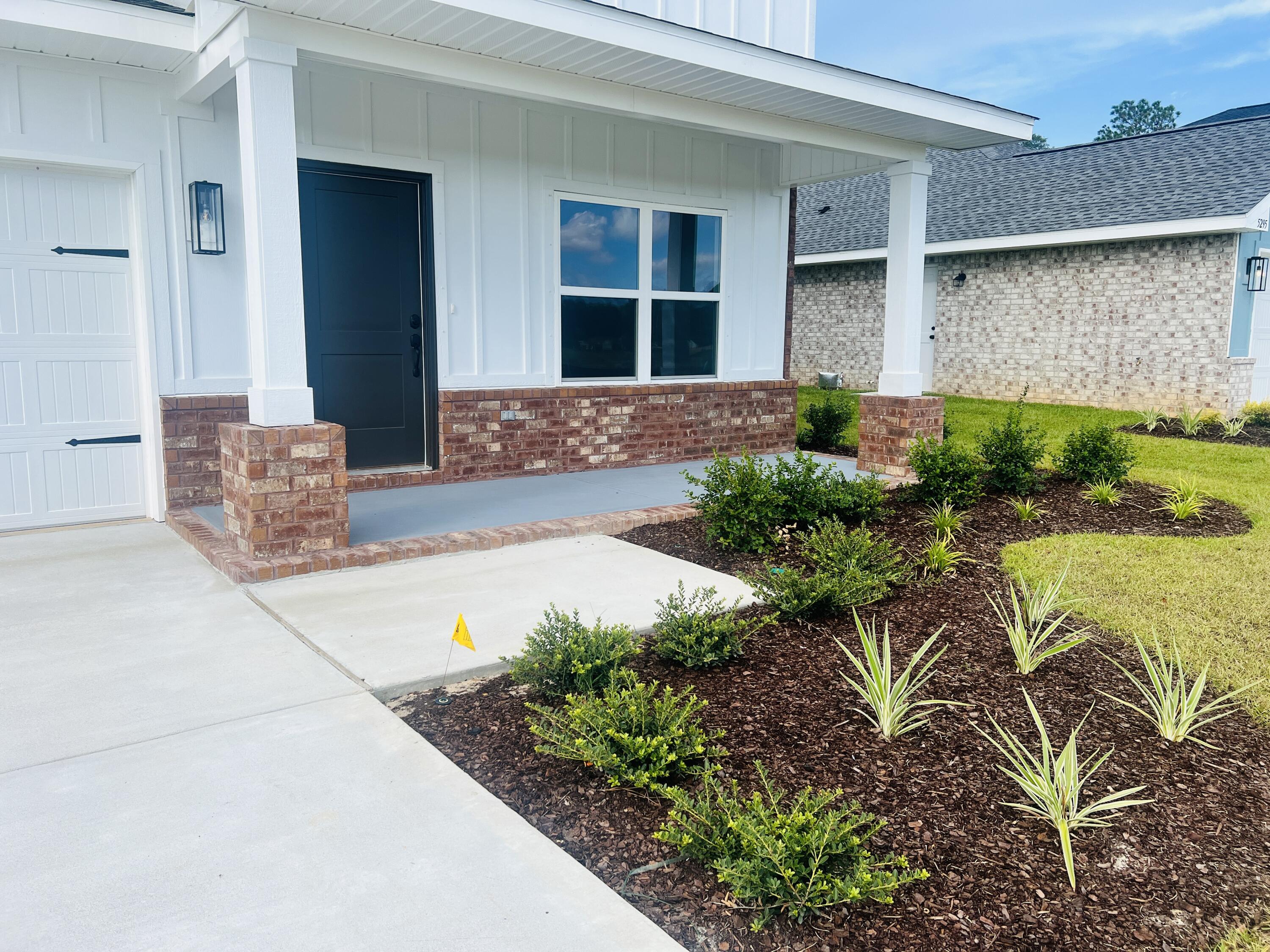 5299 Hidden Pines Circle Milton, FL 32583 - Photo 4 of 33 a front view of a house with garden