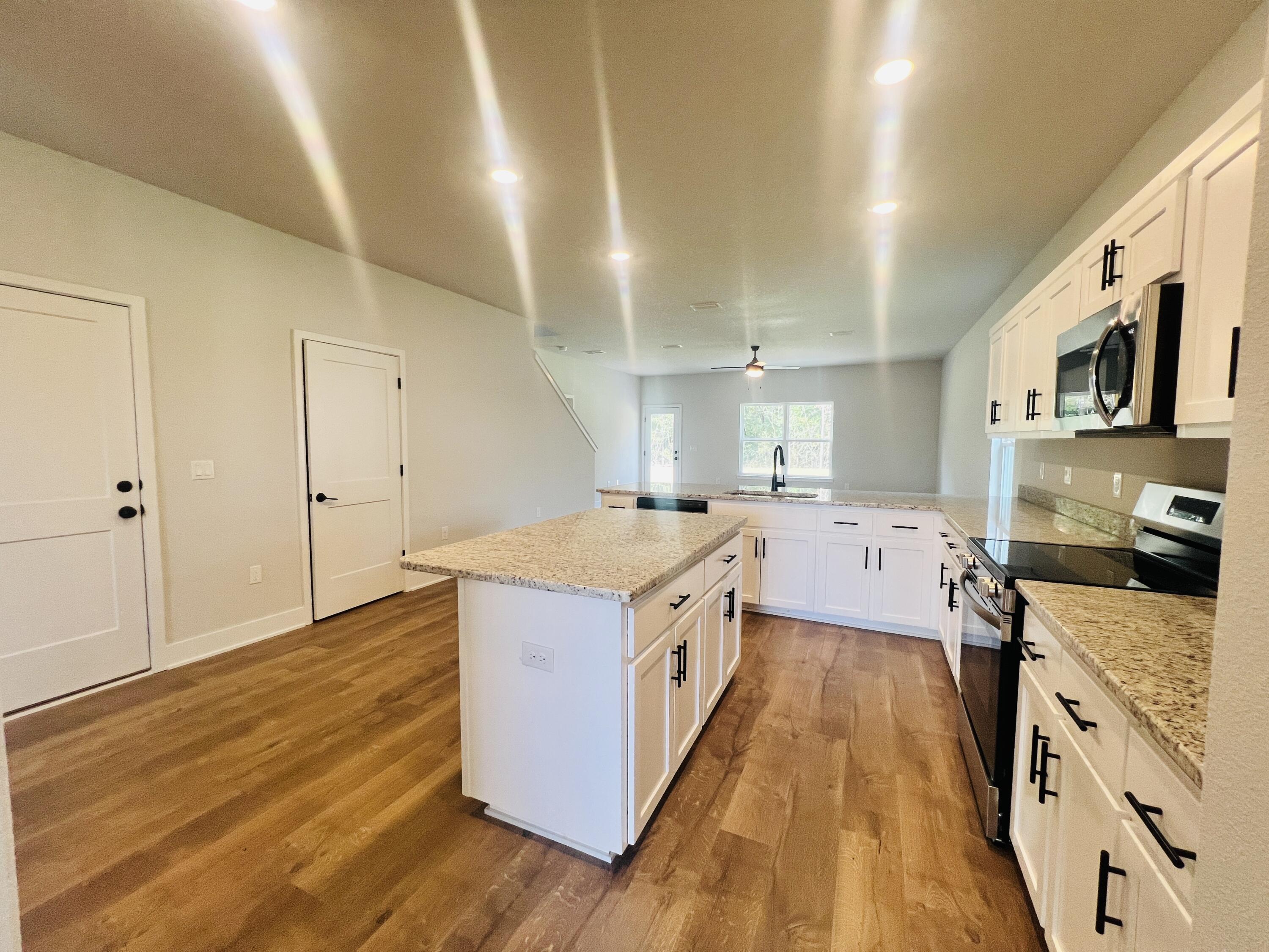 5299 Hidden Pines Circle Milton, FL 32583 - Photo 7 of 33 a large kitchen with stainless steel appliances granite countertop a stove and a wooden floors