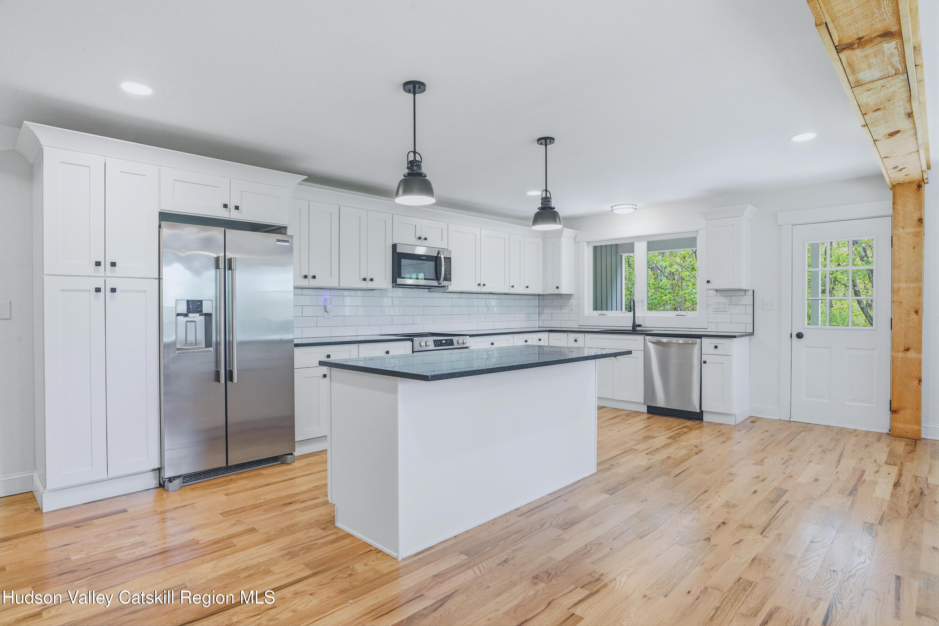 757 Taborton Road Sand Lake, NY 12153 - Photo 8 of 32 a kitchen with stainless steel appliances granite countertop a sink a stove a refrigerator and island with wooden floor