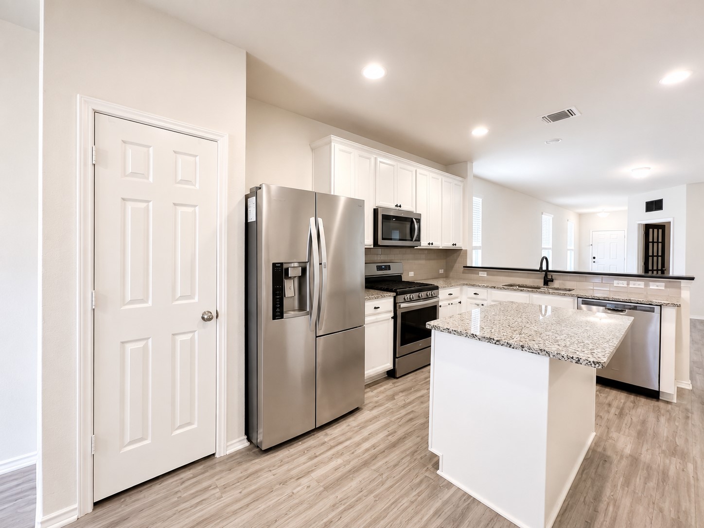 220 Pepperbark Loop Buda, TX 78610 - Photo 2 of 27 Polished granite countertops an island and stainless steel appliances anchor this modern culinary space.