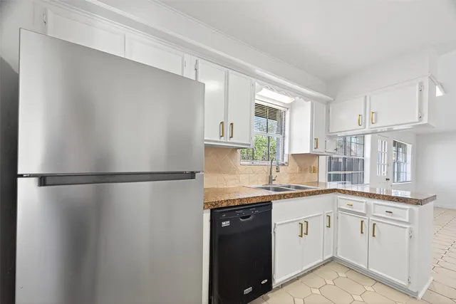 a kitchen with a sink a refrigerator a window and cabinets
