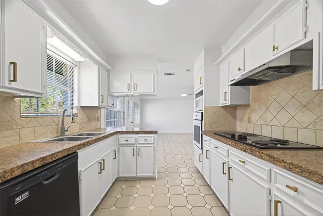 a kitchen with stainless steel appliances granite countertop a sink stove and cabinets