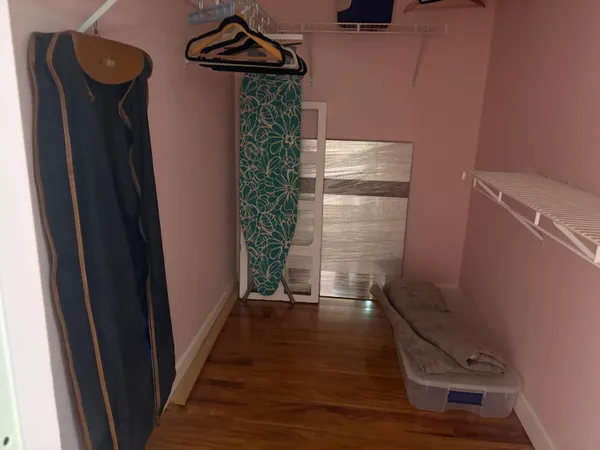 a view of empty room with wooden floor