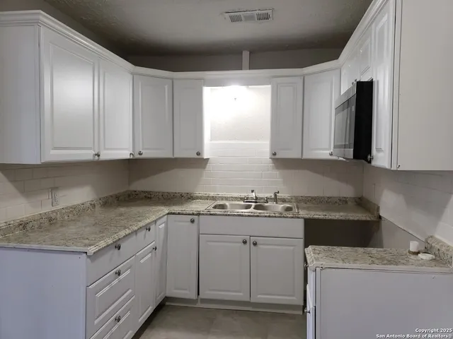 a kitchen with a sink stove and cabinets