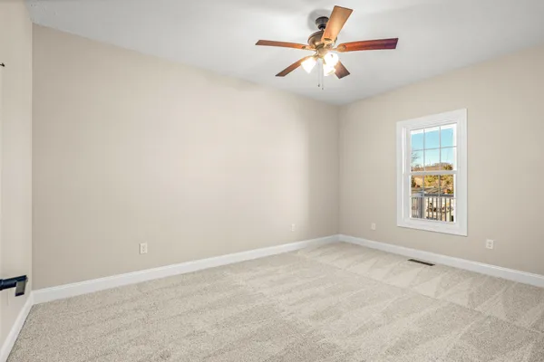 an empty room with a window and a fan