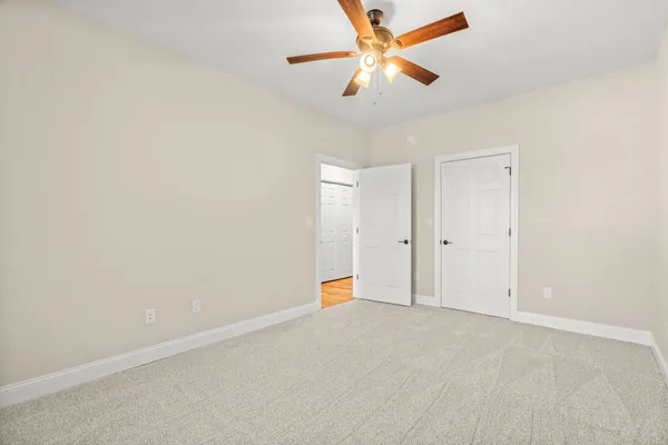 an empty room with chandelier fan