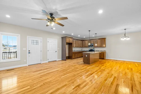 a kitchen with stainless steel appliances kitchen island a refrigerator sink and white cabinets