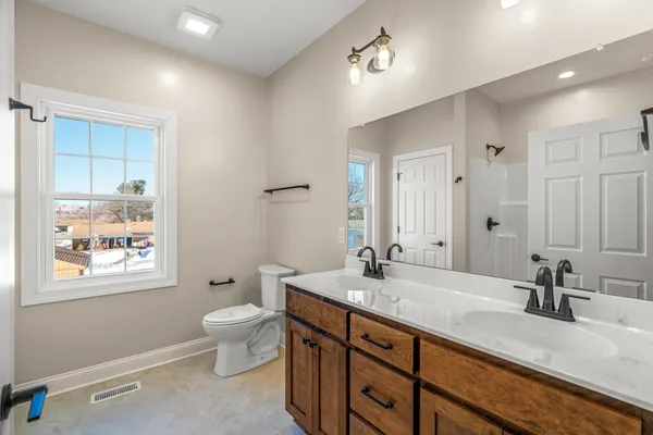 a bathroom with a granite countertop sink mirror and toilet