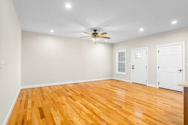 a view of an empty room with cabinet and a ceiling fan