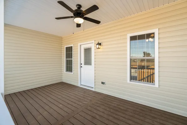 a view of a big room with wooden floor and a ceiling fan
