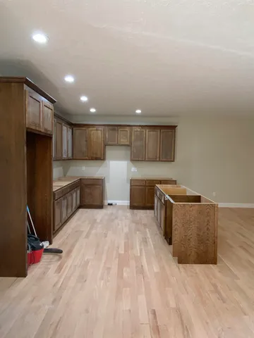 a kitchen with stainless steel appliances kitchen island granite countertop a refrigerator and a stove top oven