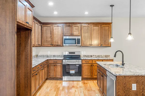 a kitchen with stainless steel appliances granite countertop a sink stove and cabinets