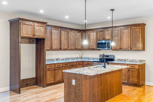 a kitchen with stainless steel appliances granite countertop a sink stove and refrigerator