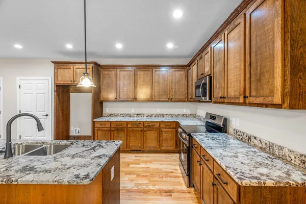 a kitchen with a stove a sink and a wooden cabinets