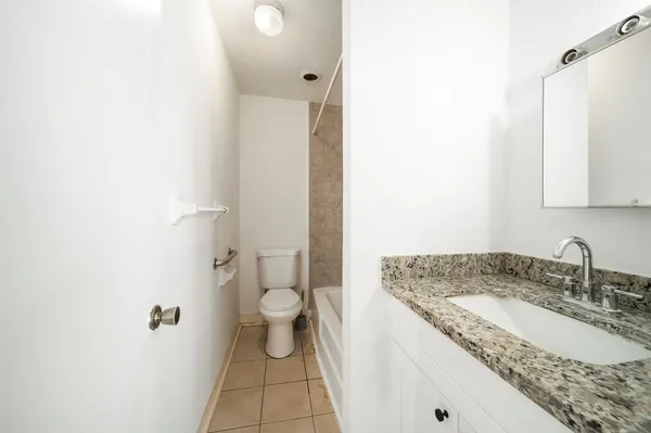 a bathroom with a granite countertop sink and a mirror