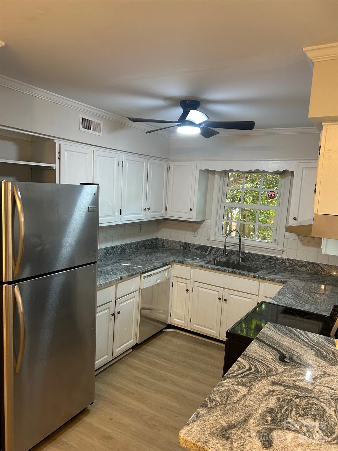 2227 Rexford Road Charlotte, NC 28211 - Photo 16 of 31 a kitchen with granite countertop a refrigerator a sink dishwasher a stove and white cabinets next to a window