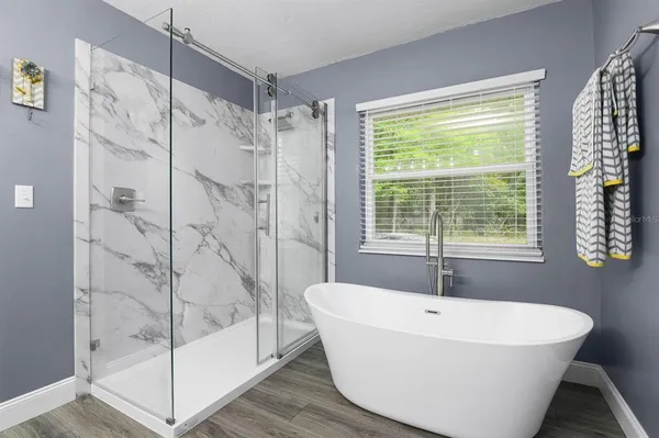 a white bath tub sitting next to a shower