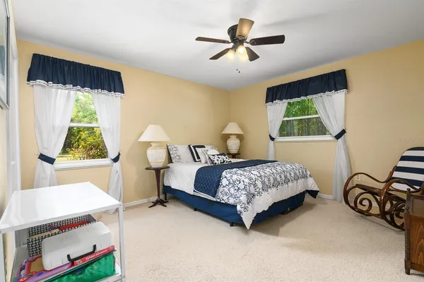 a spacious bedroom with a bed a chandelier and a window