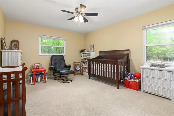 a bedroom with furniture and a large window