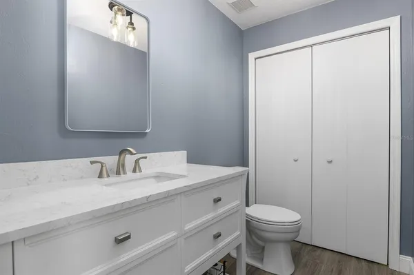 a bathroom with a toilet a sink and mirror