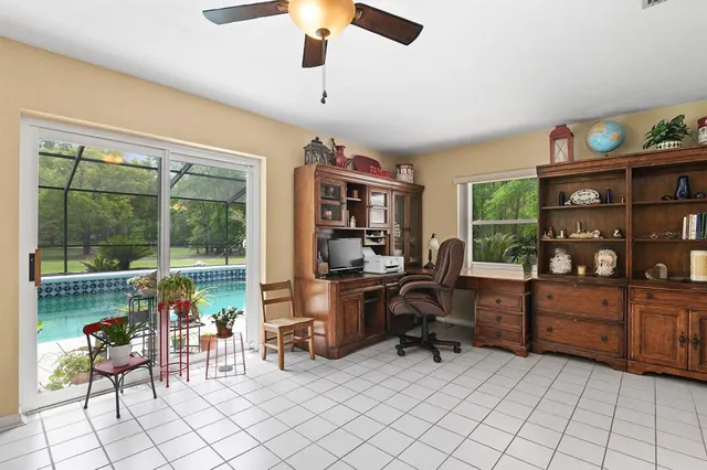a view of a workspace with furniture and a window