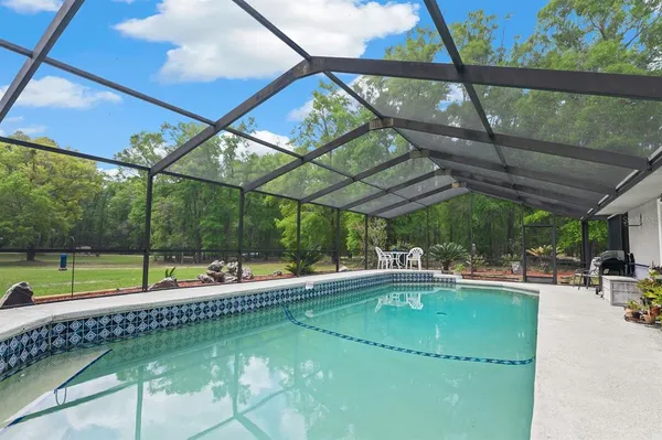 a swimming pool with outdoor seating and yard