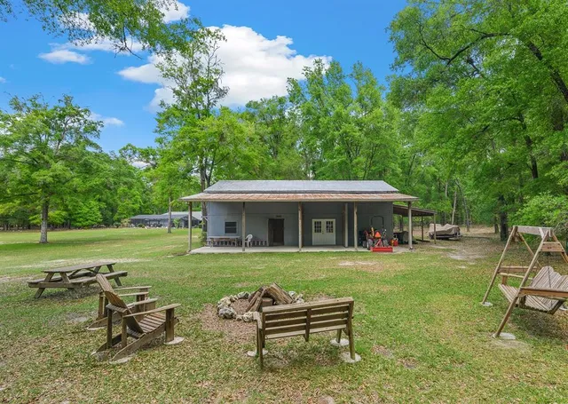 a backyard of a house with table and chairs