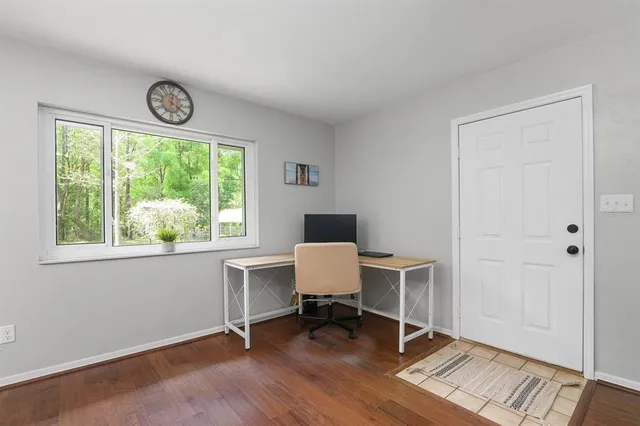 a view of workspace with wooden floor windows and chair