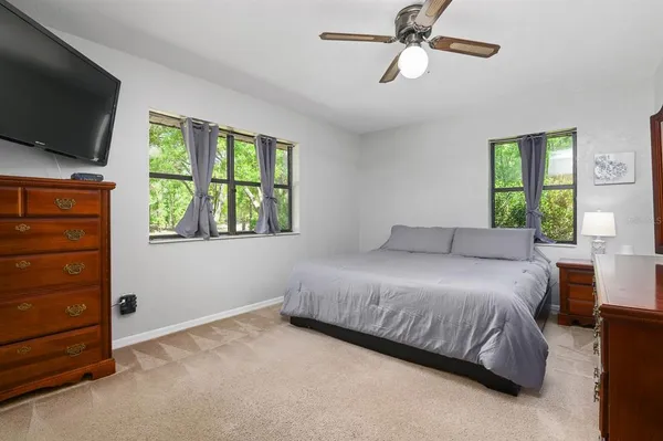a bedroom with a bed and a flat tv screen on dresser