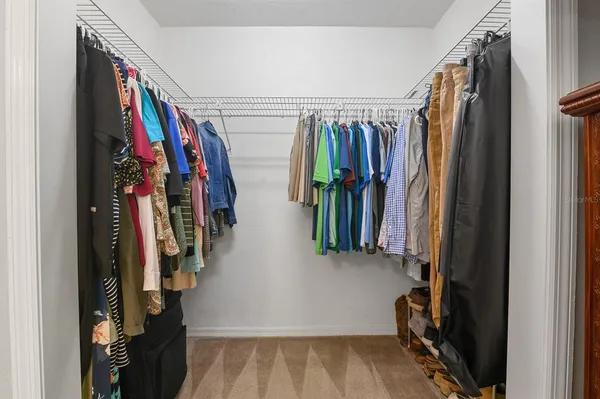 a view of walk in closet with clothes and shoes