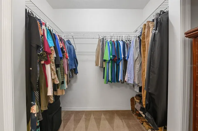 a view of walk in closet with clothes and shoes