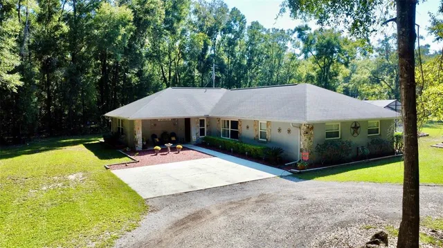 a view of a house with backyard and sitting area