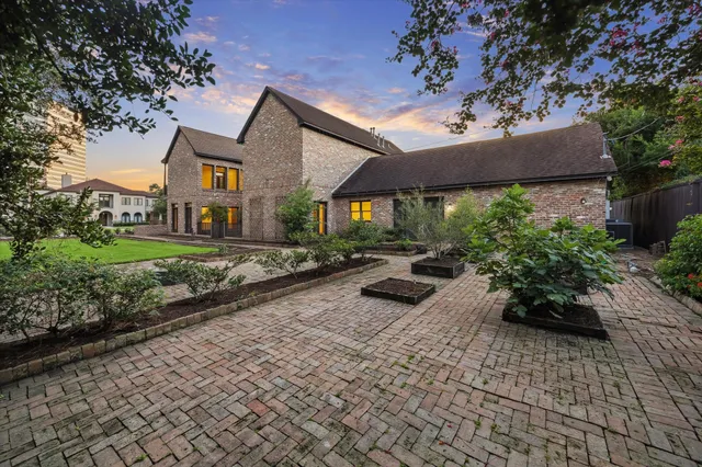 a view of a patio with table and chairs potted plants and large tree