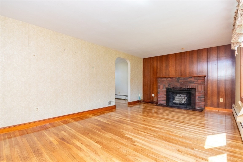 5 Edward Street Canton, MA 02021 - Photo 5 of 24 a view of an empty room with wooden floor fireplace and a window