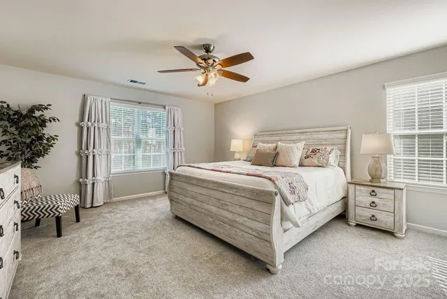 a spacious bedroom with a bed and a chandelier