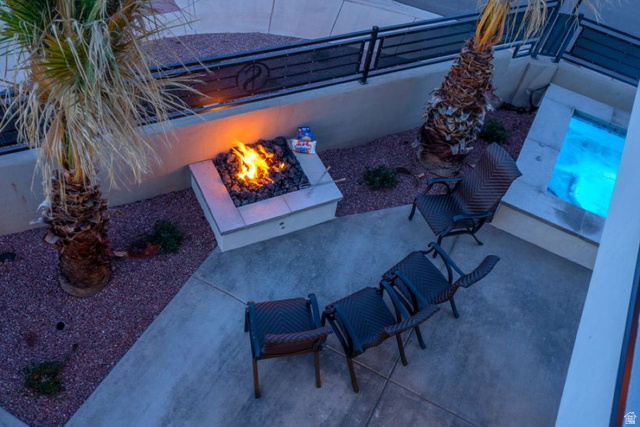 2600 Ocotillo Way, Unit 31 Santa Clara, UT 84765 - Photo 66 of 73 Outdoor patio featuring a built-in fire pit, a spa with blue lighting, and mature palm trees
