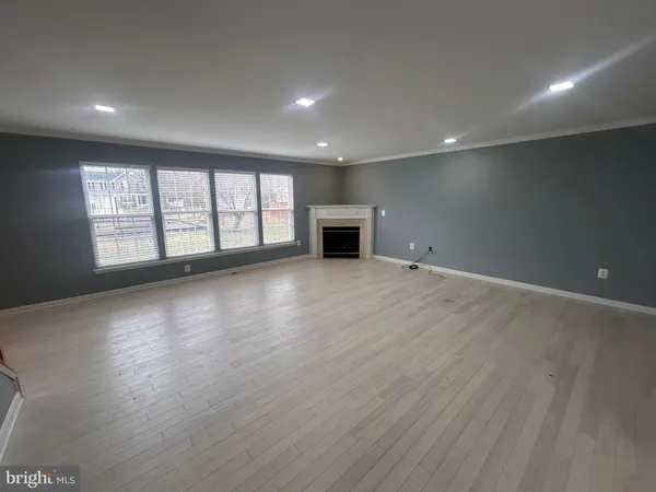 an empty room with wooden floor and fireplace