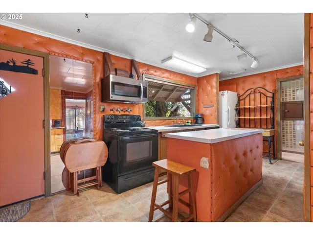 a kitchen with stainless steel appliances kitchen island granite countertop a stove a sink and a dining table