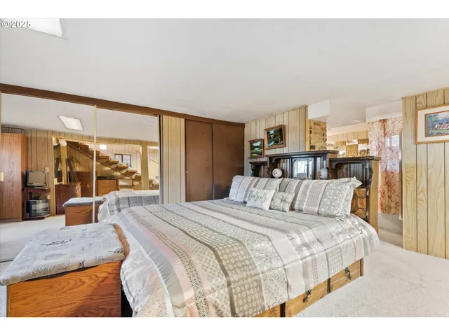 a bedroom with a large bed and a large mirror